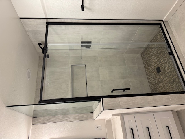 Bathroom remodel — framed glass shower with pebble floor and tile surround