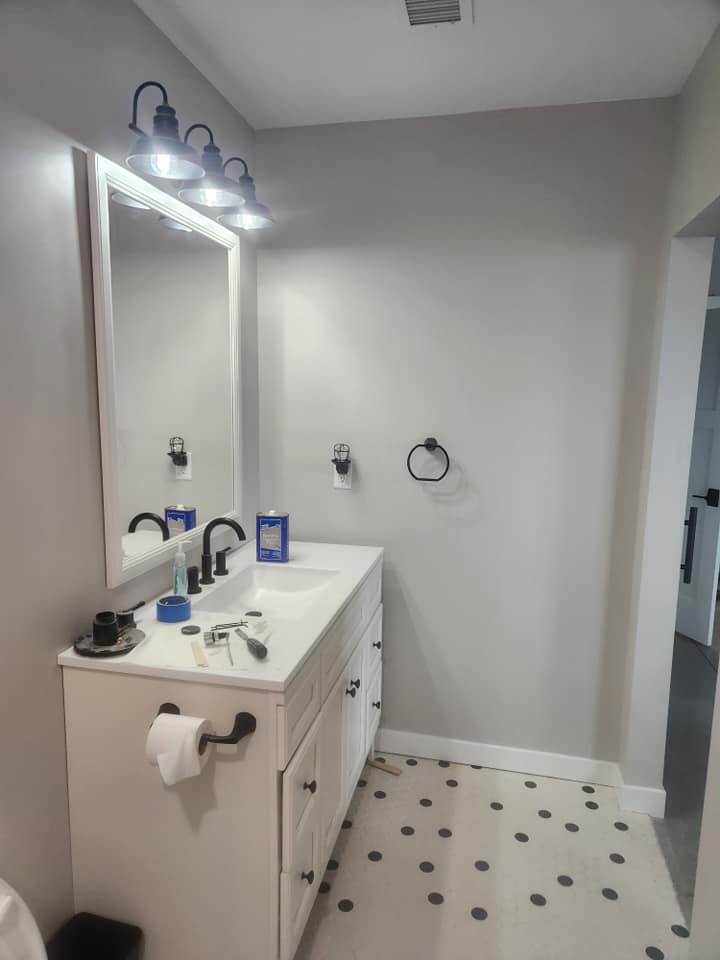 Custom home — bathroom with white vanity, framed mirror, and polka-dot tile floor
