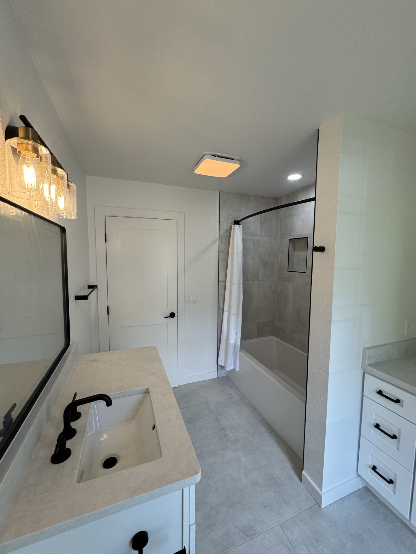 Bathroom remodel — tile tub-shower surround with framed glass and dual vanities
