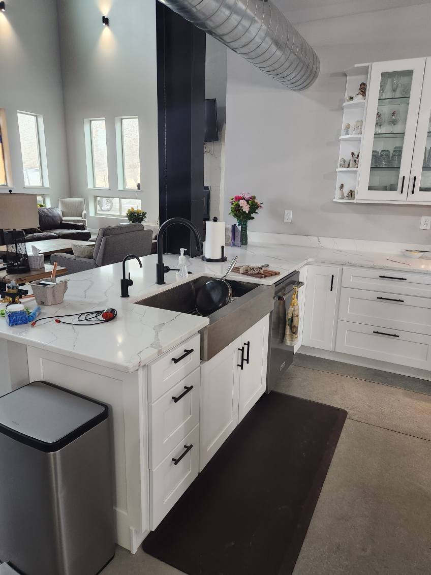 Custom home — kitchen peninsula with farmhouse sink, quartz counters, and white shaker cabinets