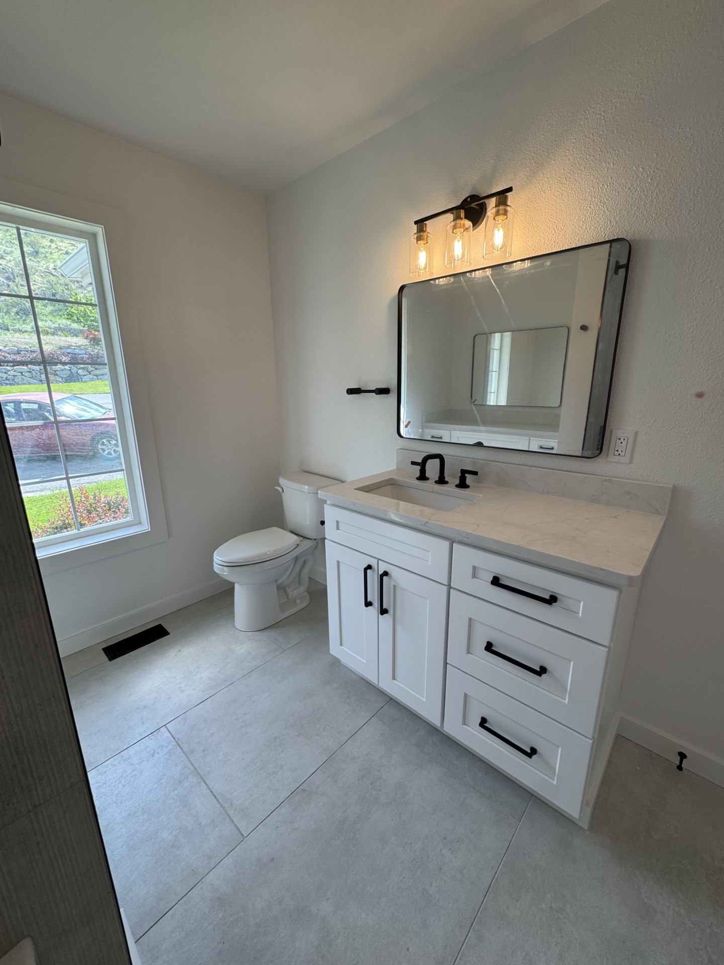 Chelan WA bathroom remodel — finished bathroom with toilet, vanity, and large-format tile floor