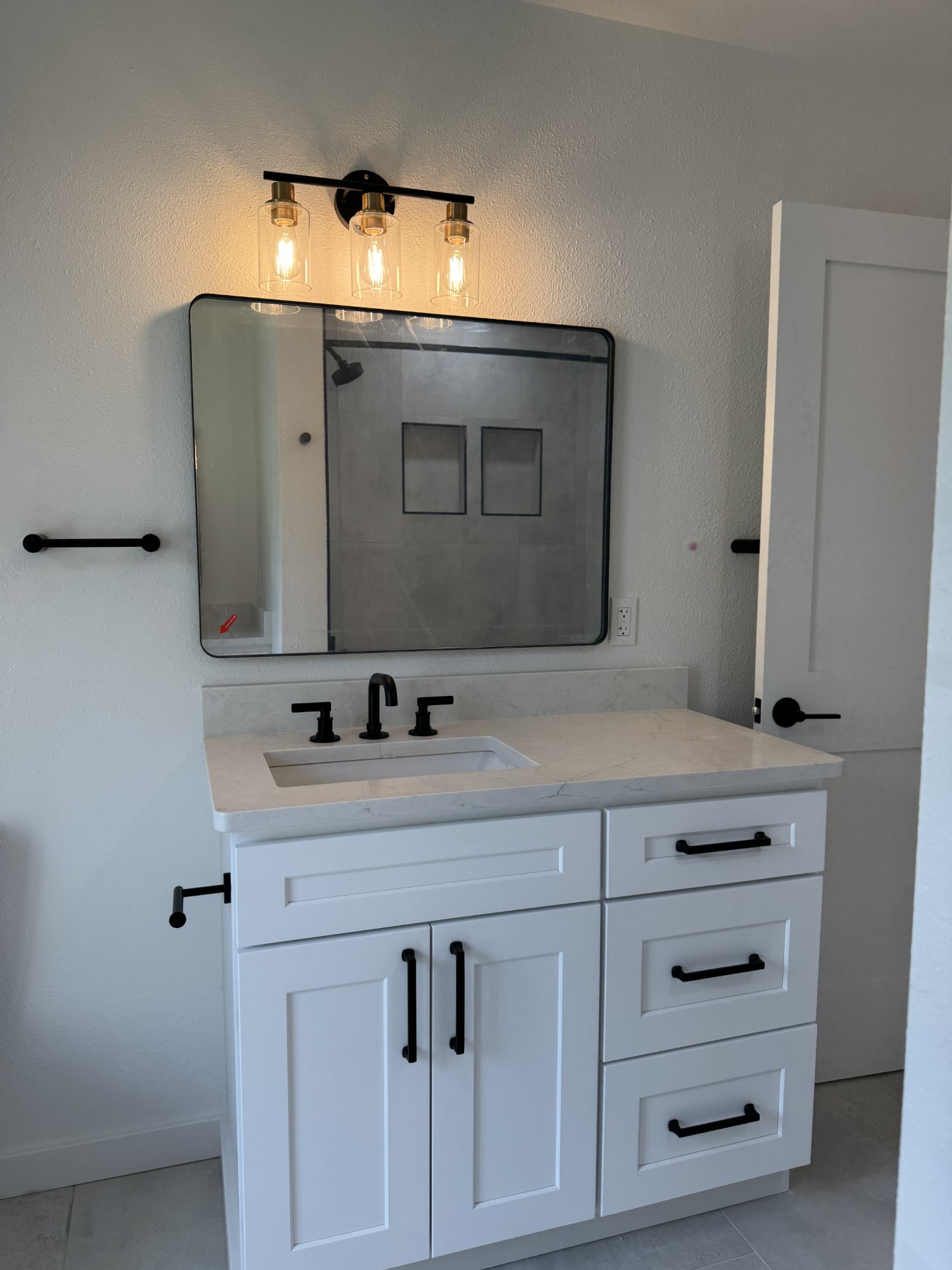 Chelan WA bathroom remodel — single-sink vanity with framed mirror and Edison vanity lights
