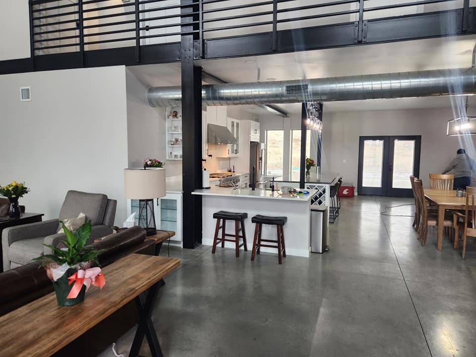 Custom home — open-concept living and kitchen with steel mezzanine and exposed ductwork